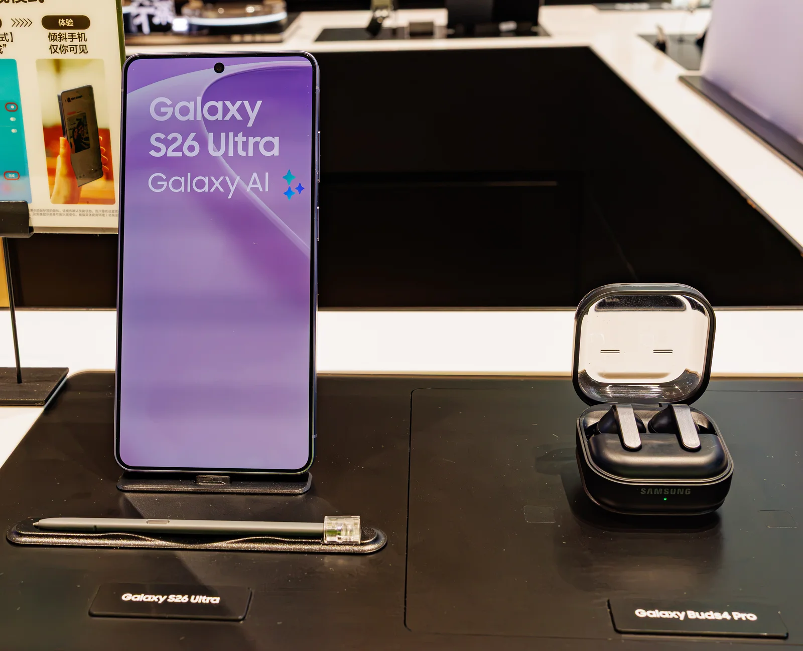 Galaxy Buds4 Pro в открытом зарядном футляре рядом с Galaxy S26 Ultra